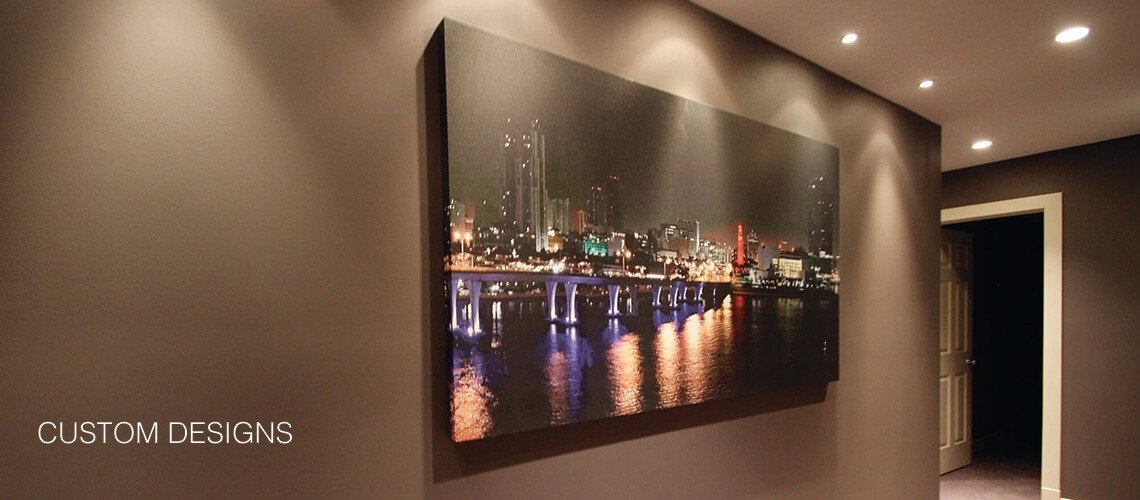 Custom canvas wrapped photo of Florida night shot over water which has been hung on a wall with pot lighting that accentuates the image.